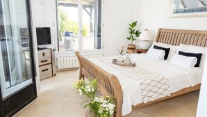 A bedroom with a bed, bedside table, lamp, and a window with a view of greenery. - Villa 'Casa Trebol - Private Pool' with Mountain View, Wi-Fi and Air Conditioning (Murcia)