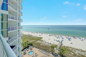 A high-rise hotel with a pool area, beach view, and multiple balconies. - Palacio 704 | Beachfront, Resort Amenities | My Beach Getaways (Pensacola)