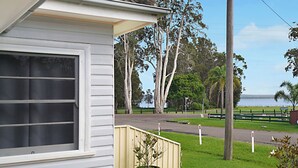 A house with a window, a small shed, and a grassy yard with trees. - Long Jetty Lake House -Long Jetty, Central Coast Fully Renovated 3 bed Cottage,  (Long Jetty)