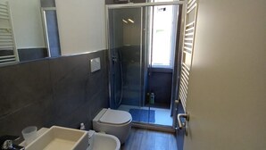 A bathroom with a shower, toilet, and sink. - Hostmate- Milano - Piazza Insubria (Milano)