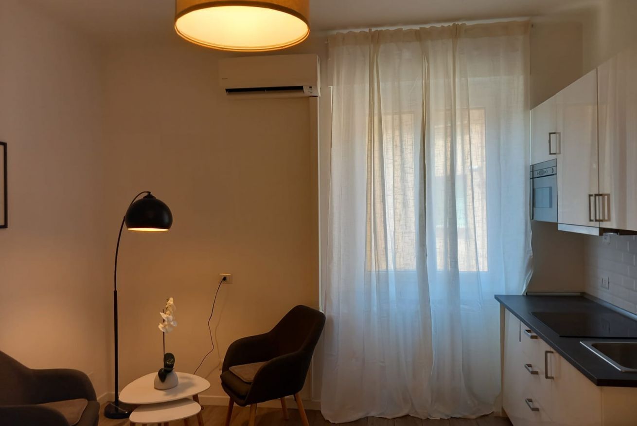 Eine moderne Küche mit Essbereich, inklusive Stuhl, Tisch und Pendelleuchte.