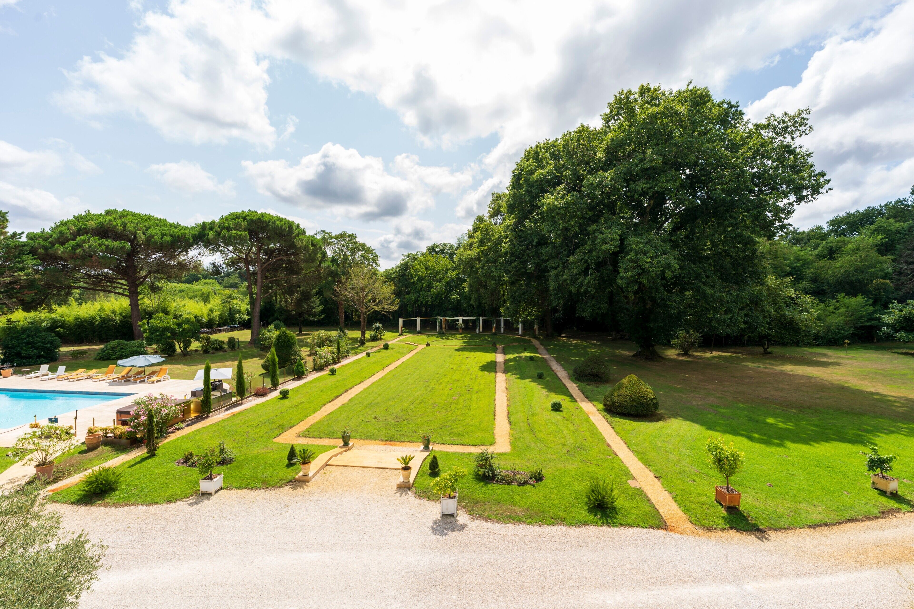 Ein angelegter Garten mit Schwimmbecken, Wegen und ordentlich gestutztem Rasen.