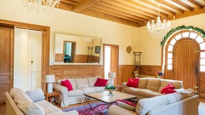 Una sala de estar acogedora con vigas de madera, un candelabro y un espejo grande.