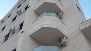 A high-rise building with multiple balconies and air conditioning units. - Royal House (Irbid)