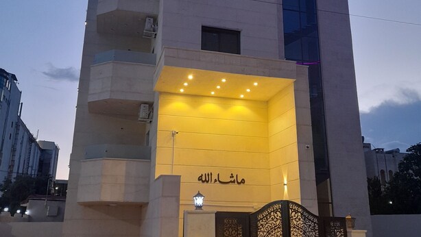A modern building with a sign reading "10" and "Ma'ash Allah" at the entrance. - Royal House (Irbid)