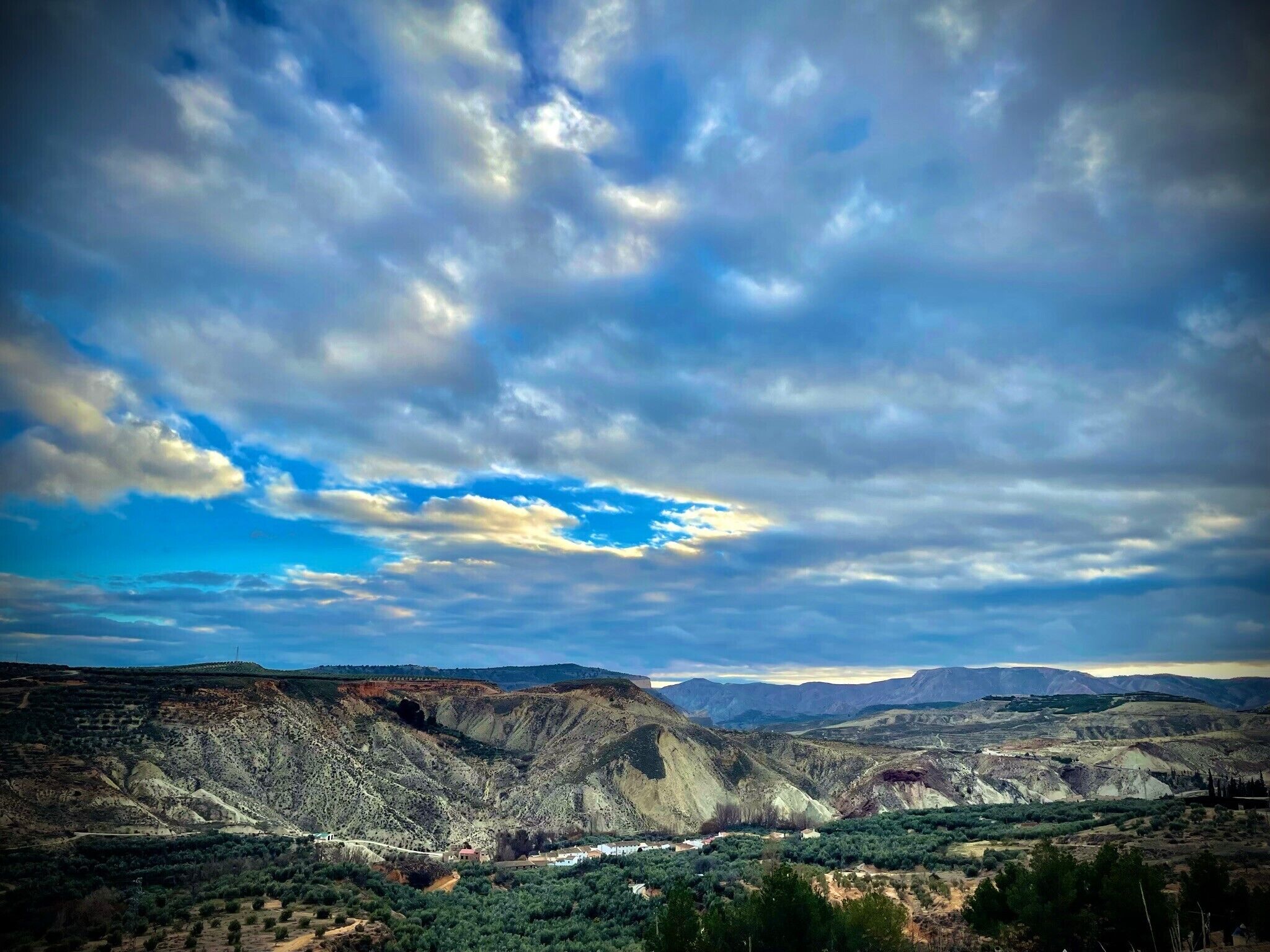 Paesaggio montuoso con una valle e un ponte.
