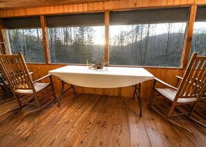 A room with a wooden floor, a round table, and two wooden chairs. - Charming & Historical 3-bedroom cabin in marvelous Franklin with AC, fast WiFi (Franklin)