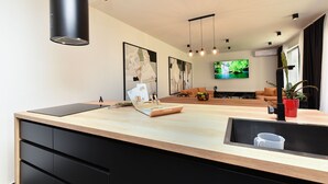 Una cocina moderna con una isla central, armarios negros e iluminación colgante.