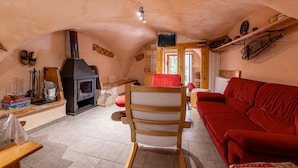 Un salón acogedor con chimenea, muebles de madera y un sofá rojo.