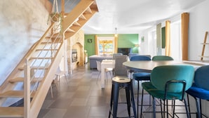 Un intérieur moderne comprenant un escalier, un coin repas et une cuisine.