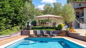 A swimming pool with lounge chairs and a pergola.