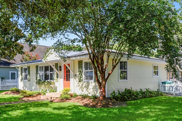 A single-story house with a front porch, a small garden, and a tree in front. - The Lemonade Stand - the PERFECT location in Ocean Springs. Walk to downtown! (Ocean Springs)