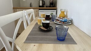 Une table de petit-déjeuner avec des tasses, un verre et de la nourriture.
