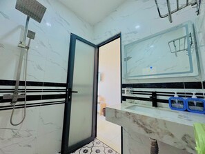 A bathroom with a shower, a sink with a mirror, and a toilet. - Haleeda Homestay Grand World Phu Quoc (Phu Quoc)
