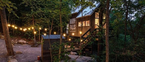 Una cabaña rústica con fachada de madera, una escalera y un letrero que dice 'Ruby Falls'.