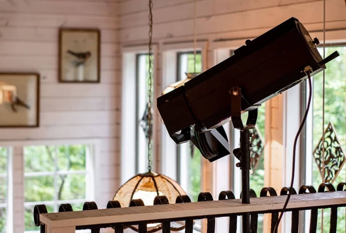 Een kamer met een houten tafel, een hanglamp en lijstwerken aan de muur.