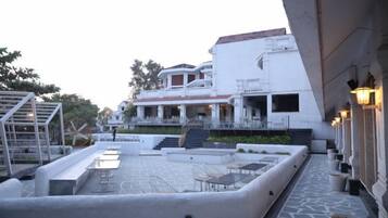 A courtyard with a pool, outdoor seating, and a building with multiple levels and balconies.