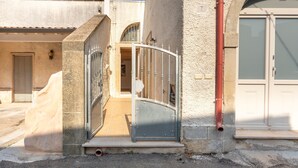 A building with a gated entrance, a visible door, and a number '7' on the wall. - Apartment 'Corte Nonna Mmela' with Private Terrace, Wi-Fi and Air Conditioning (melendugno)