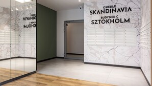 Un interior moderno con pared de vidrio, suelo de madera y un mural temático de mapa con etiquetas tipo buzón.