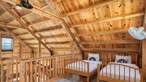 A wooden cabin with two wooden beds, a small window, and a wooden railing. - The Rustic Retreat: Elegant cabin with WiFi & AC in an enchanting location! (Pearl City)