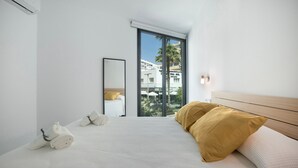 Une chambre d’hôtel moderne avec un grand lit, une vue sur la ville et un balcon.