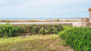 A coastal view with a paved walkway, metal railings, and a stone wall. - Penduick by Interhome (Quiberon)