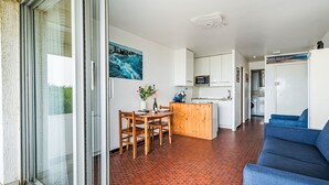 A compact living space with a dining area, kitchenette, and a blue sofa. - Penduick by Interhome (Quiberon)
