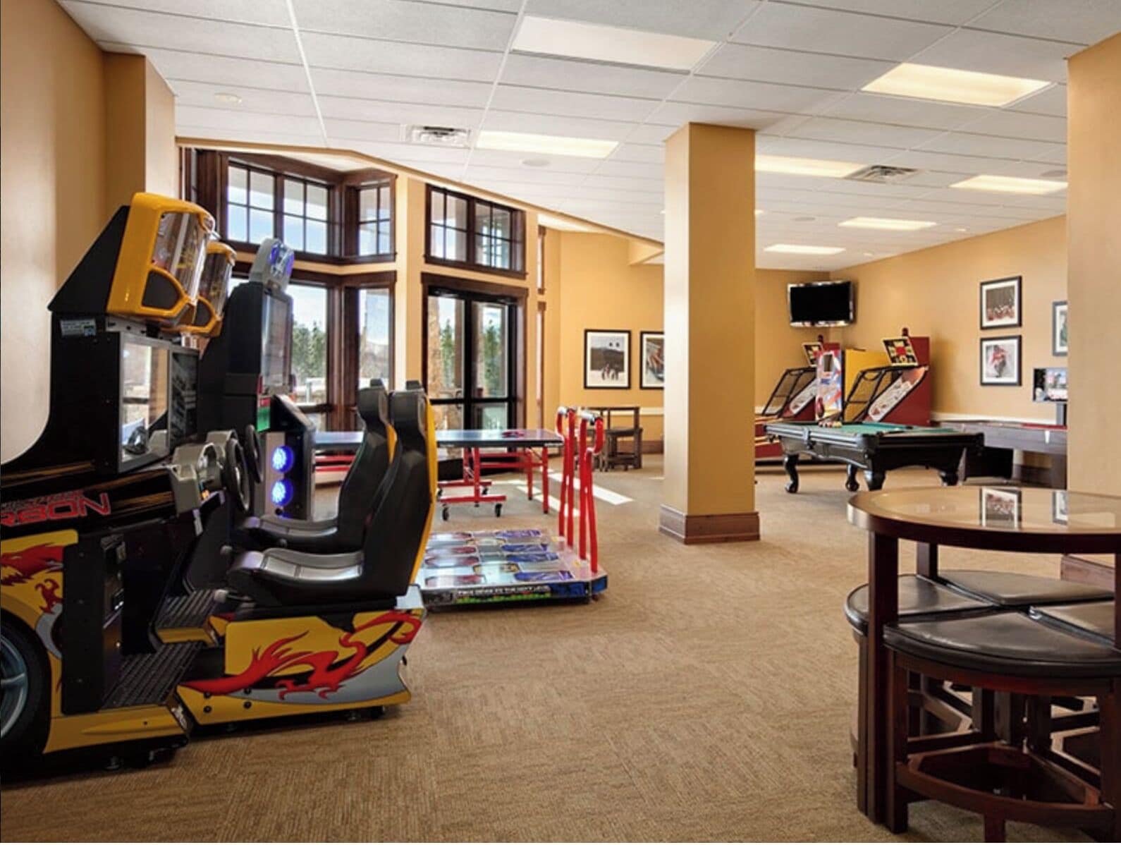A room with arcade games, a pool table, and a billiards table.