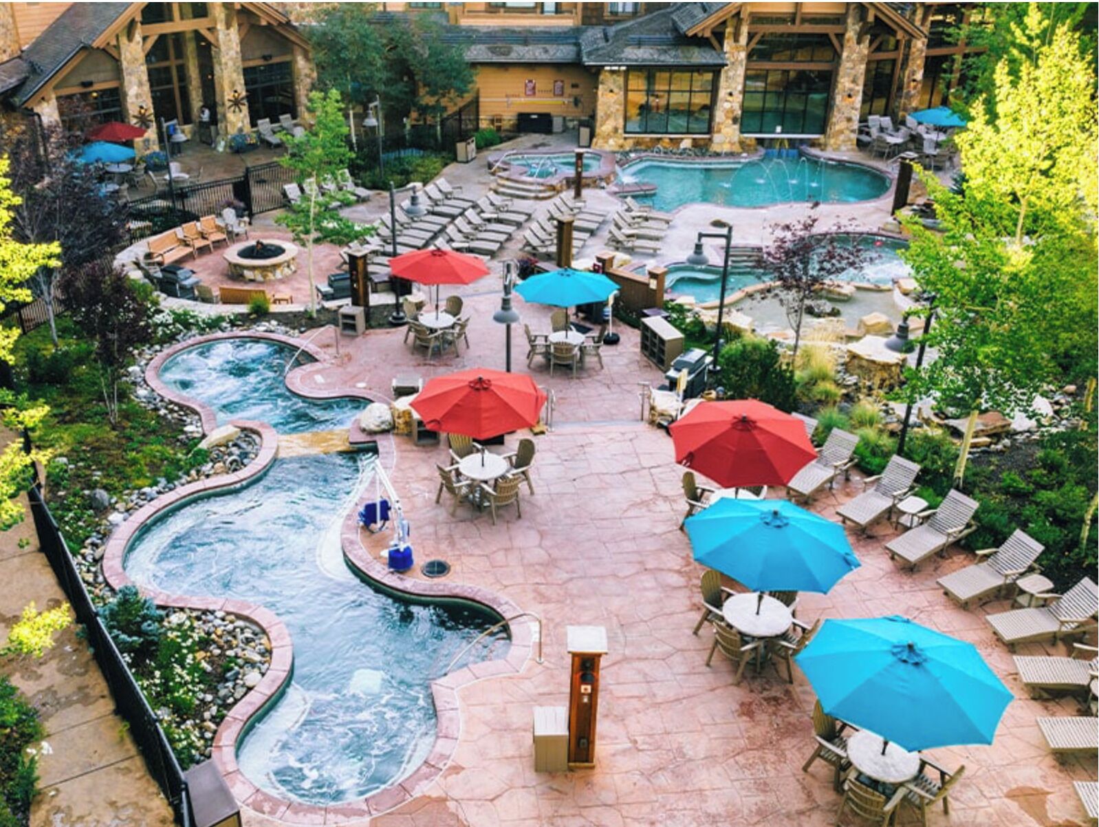 A resort with a hot tub, outdoor seating, and a pool.