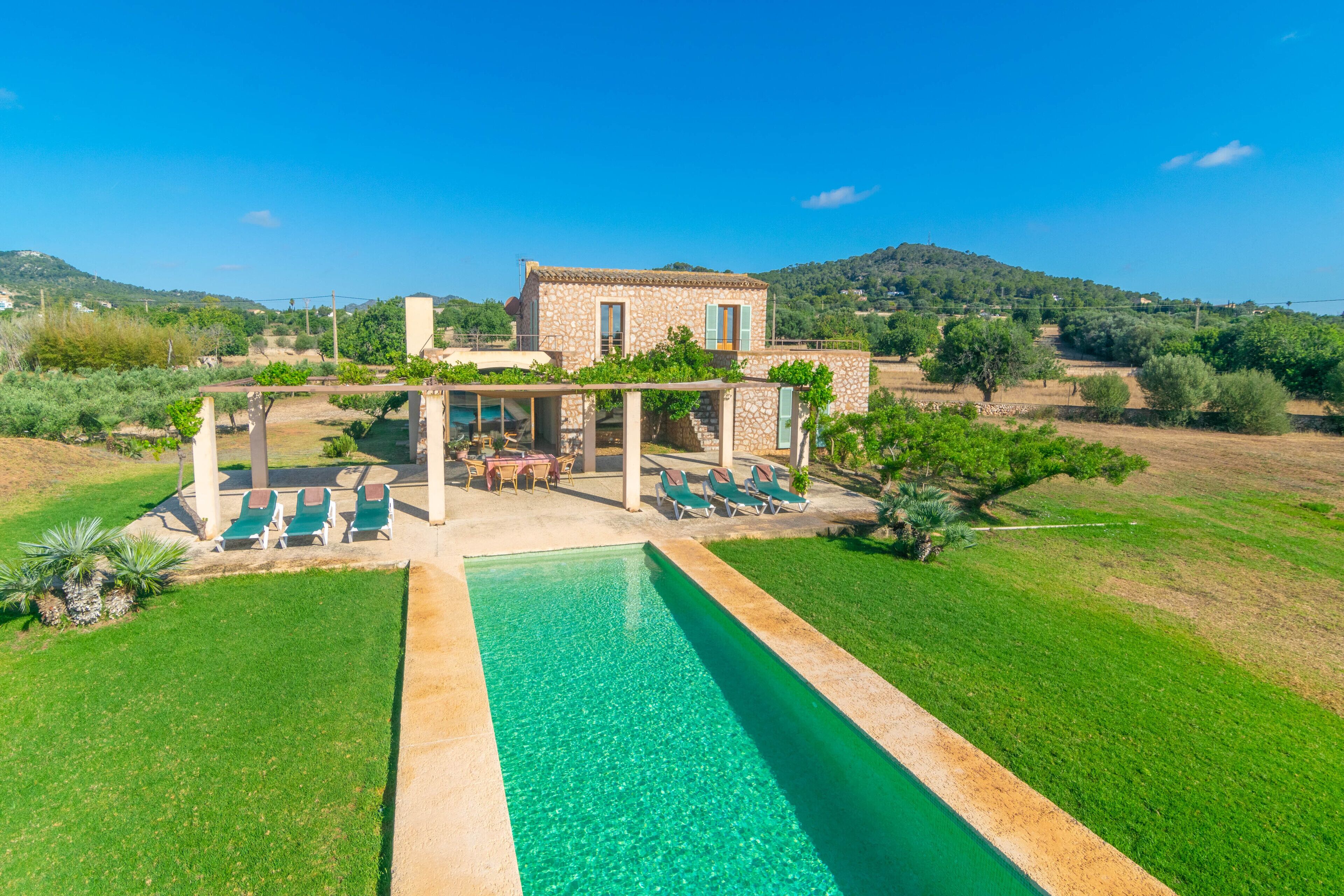 Une villa en pierre dotée d’une piscine, d’un espace extérieur aménagé et offrant une vue sur la campagne.