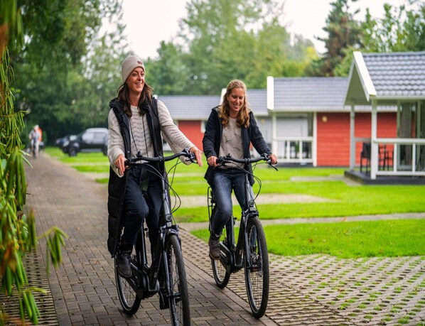 Dos personas andando en bicicleta por un camino pavimentado.