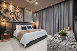 Ein modernes Schlafzimmer mit einer Steinwand, einem Bett mit weißer Bettwäsche, einem мраморному Nachttisch und einem Vorhang.