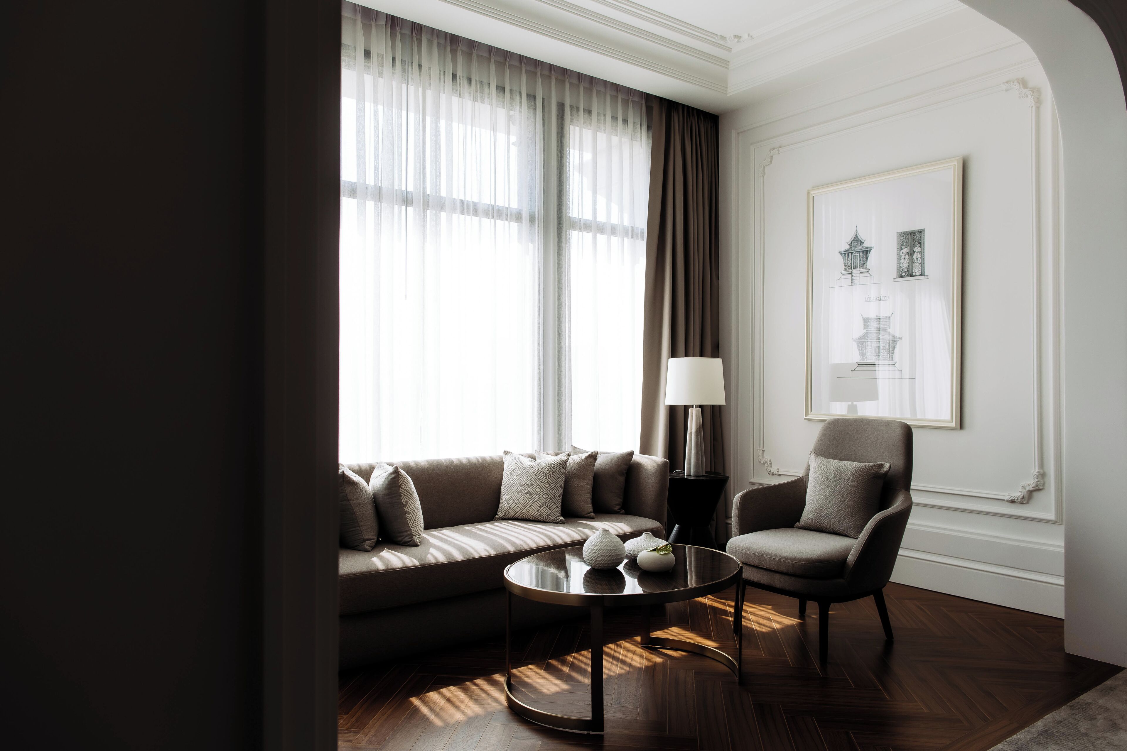 Un salon moderne avec un canapé, un fauteuil et une table basse.