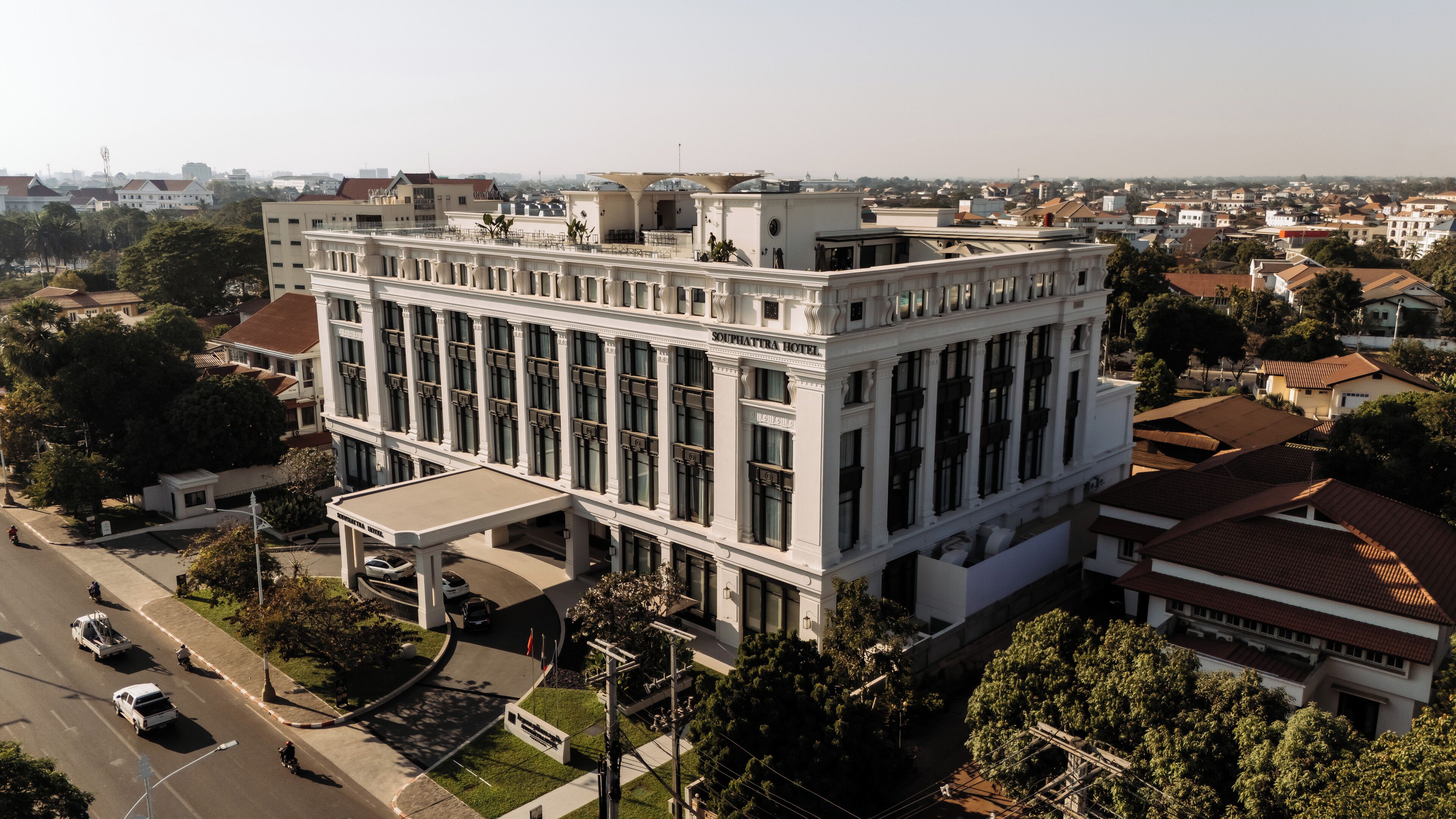 Un edifici gran i blanc de diversos pisos amb un estil arquitectònic clàssic, amb una entrada destacada i finestres amples.