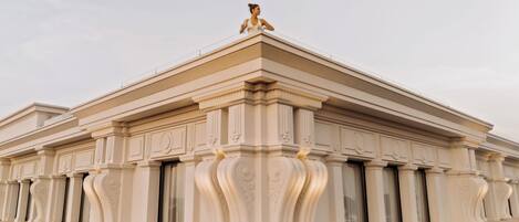 Un edificio clásico con columnas ornamentadas y una estatua en la parte superior.