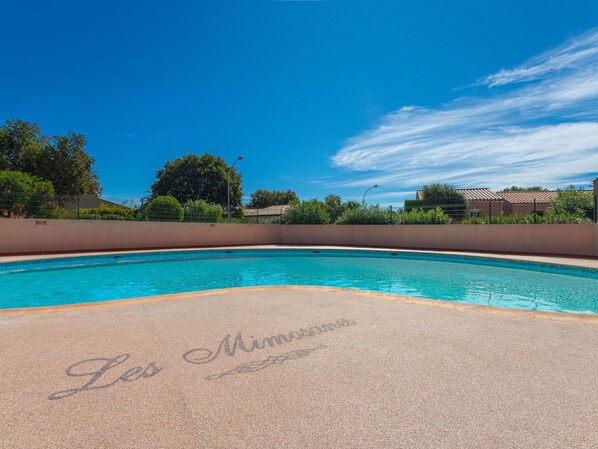 A clear blue swimming pool with a tiled deck.