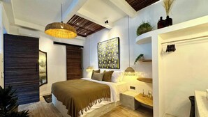 A modern bedroom with a large bed, a hanging light fixture, a painting, and a wooden ceiling. - Arcadia Lodge (Canggu)