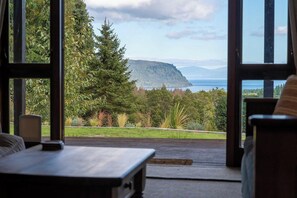 A room with a view of a mountain and a body of water.