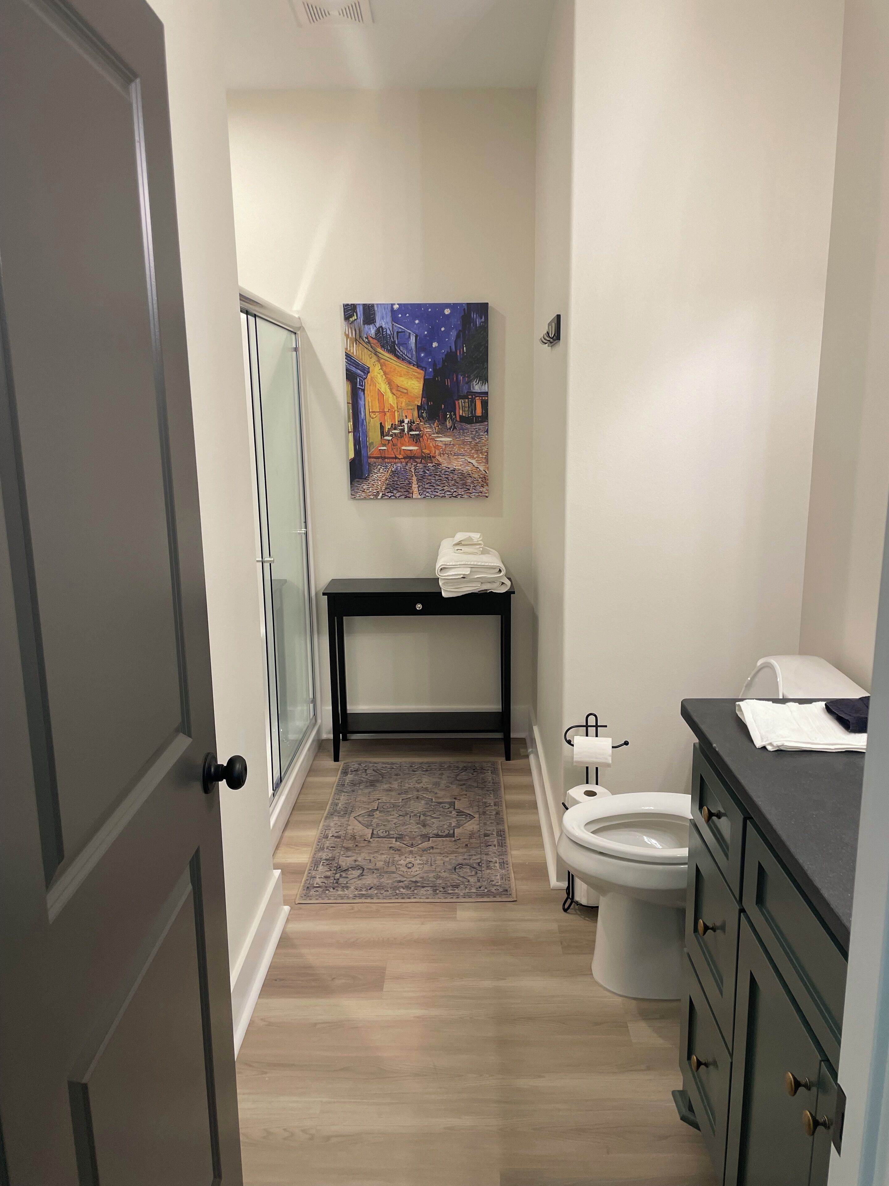 Un baño con inodoro, lavamanos y un cuadro en la pared.