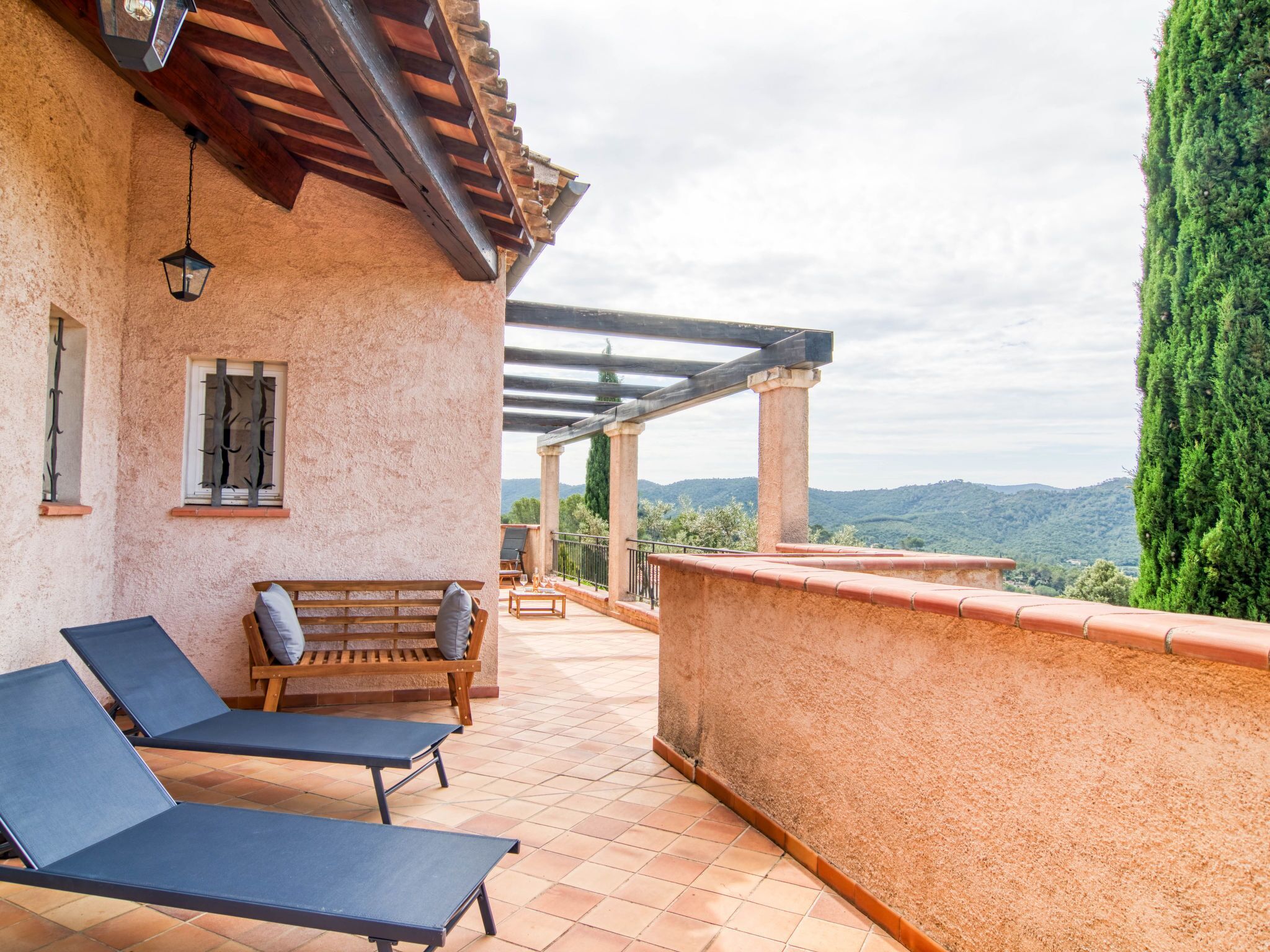 Una terrazza con due poltrone da relax, una panchina in legno e vista sulla campagna.