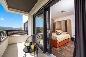 A balcony with a chair and table, a bedroom with a bed and a nightstand, and a view of the mountains. - Pool & Wellness Villa Betelgeuse Supernova, Novi Vinodolski, Croatia (Novi Vinodolski)