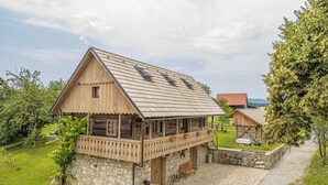 A wooden house with a balcony, stone foundation, and a gravel driveway. - Mimi Cottage w/ Sauna near Kolpa River, Gradac, Slovenia (Gradac)