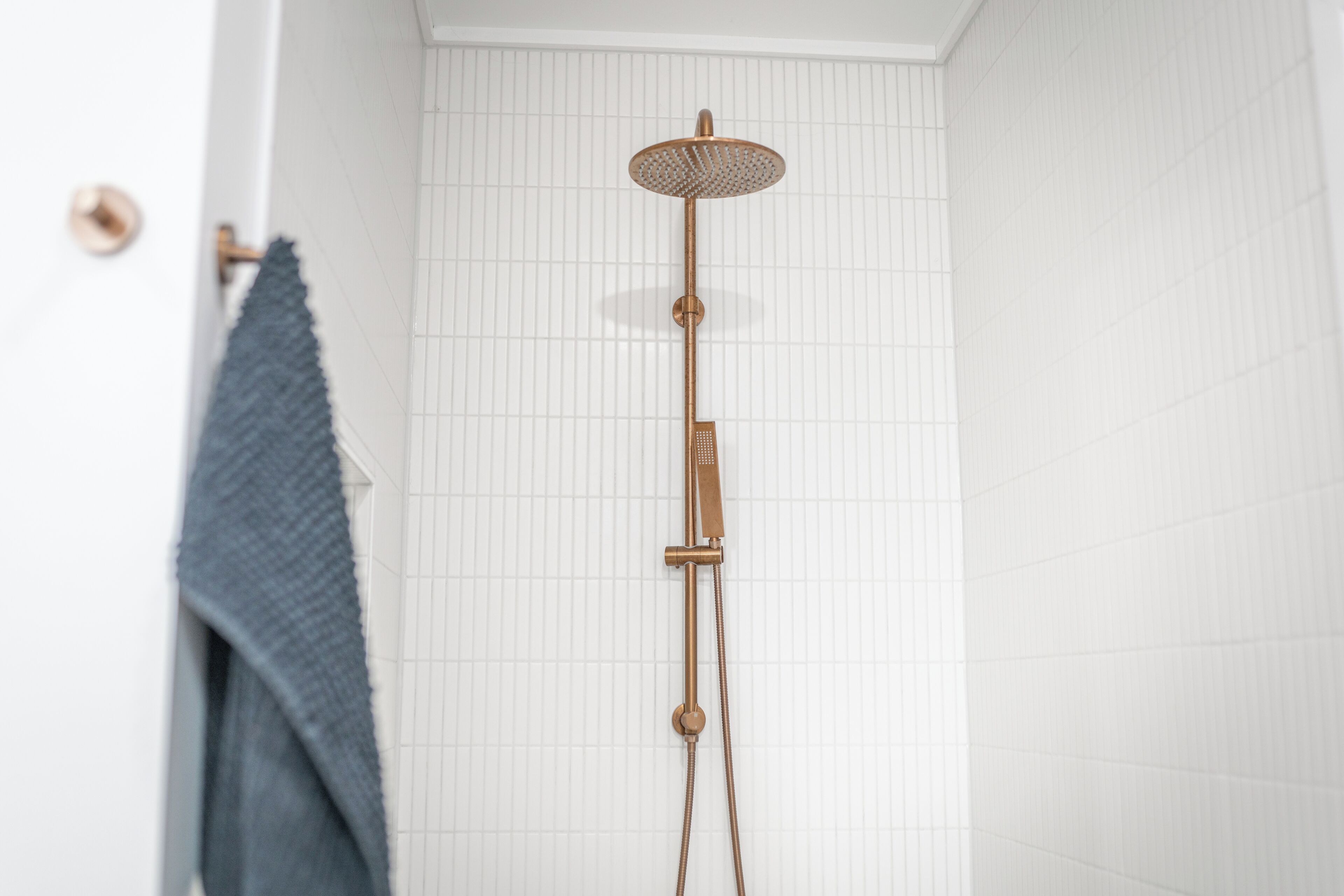 A shower with a round head and a horizontal bar.