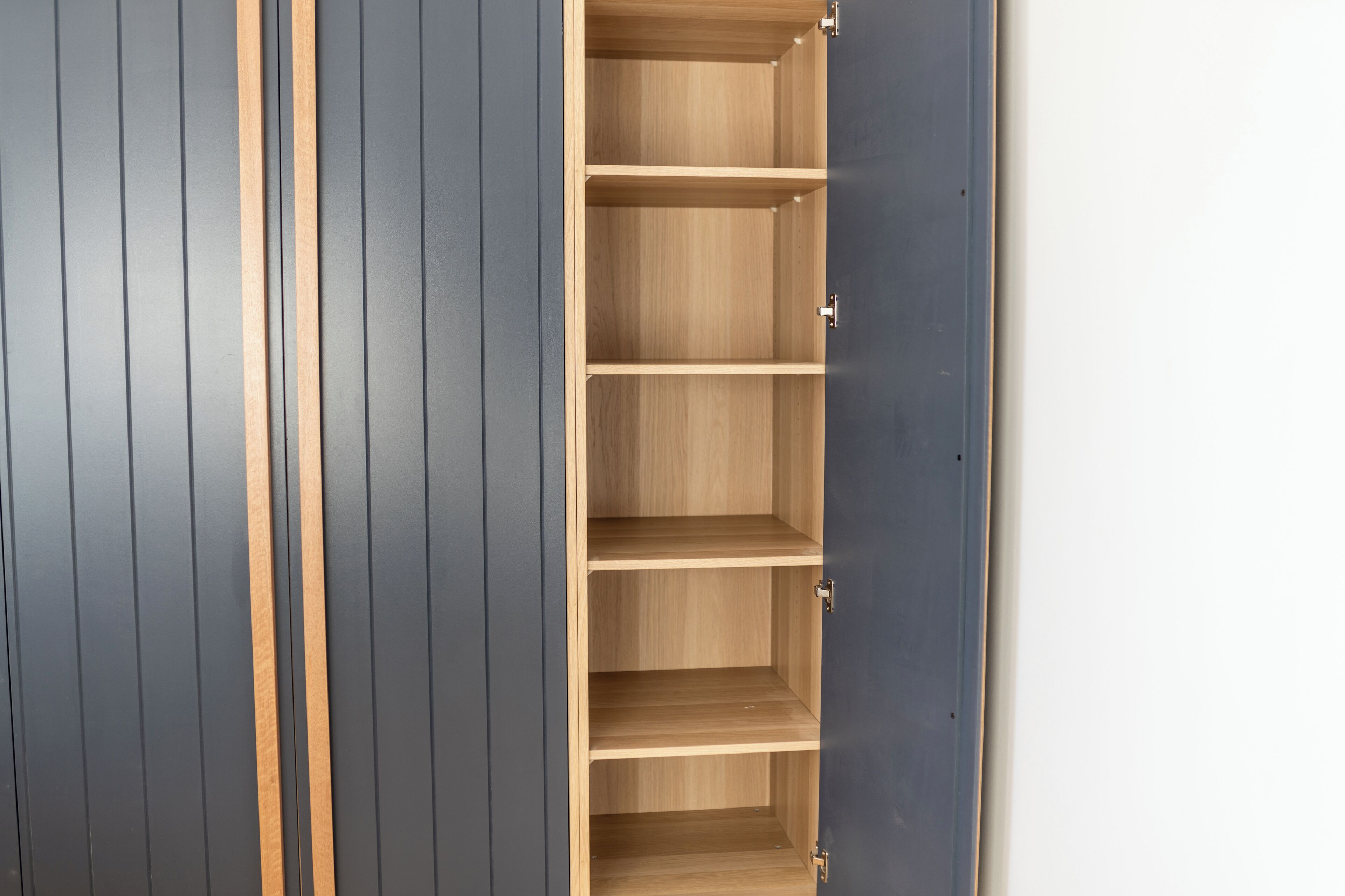 A wardrobe with multiple wooden shelves.