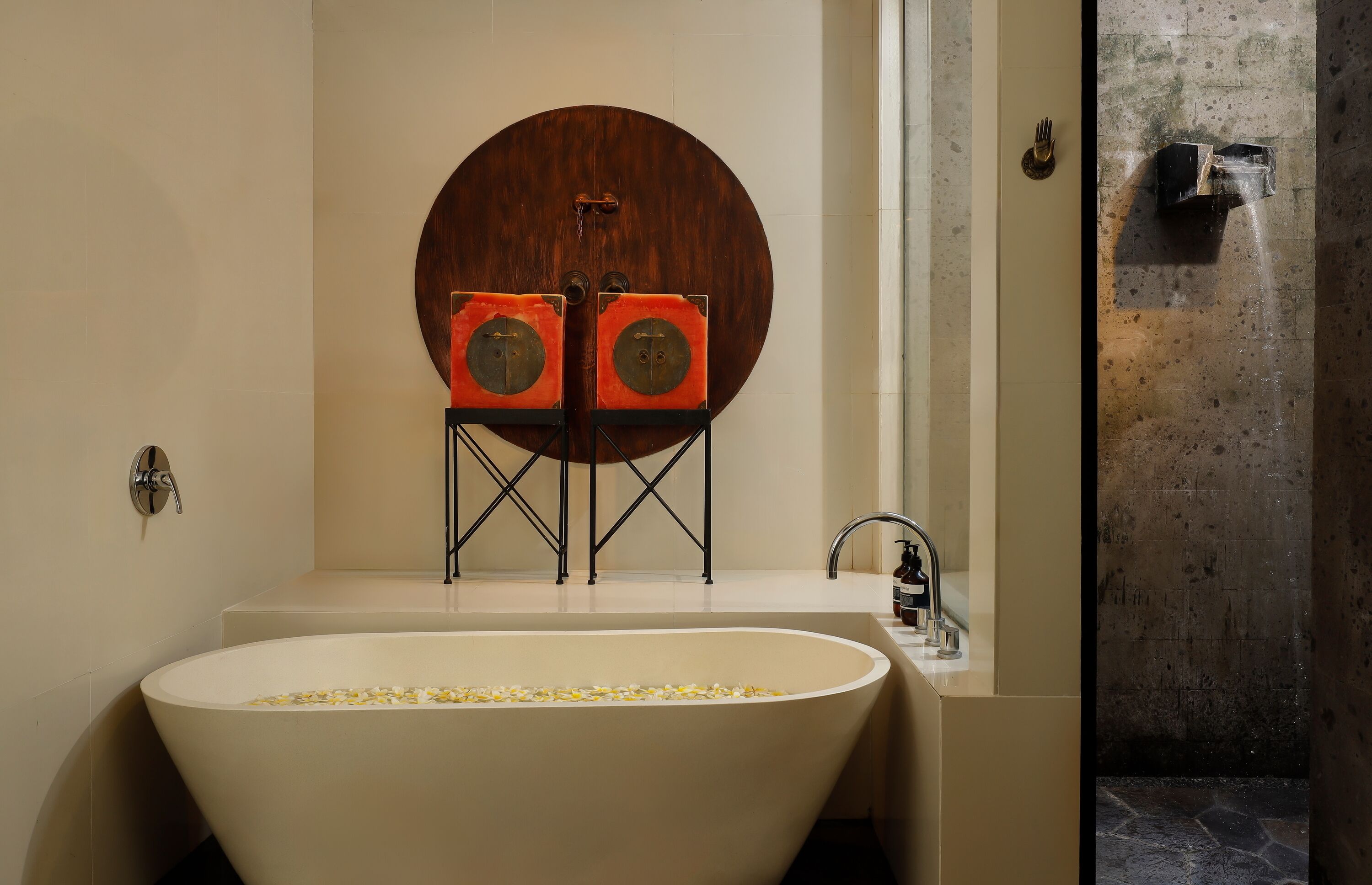 Un bagno moderno con una vasca freestanding, un ampio specchio rotondo e un originale sistema di altoparlanti a parete.