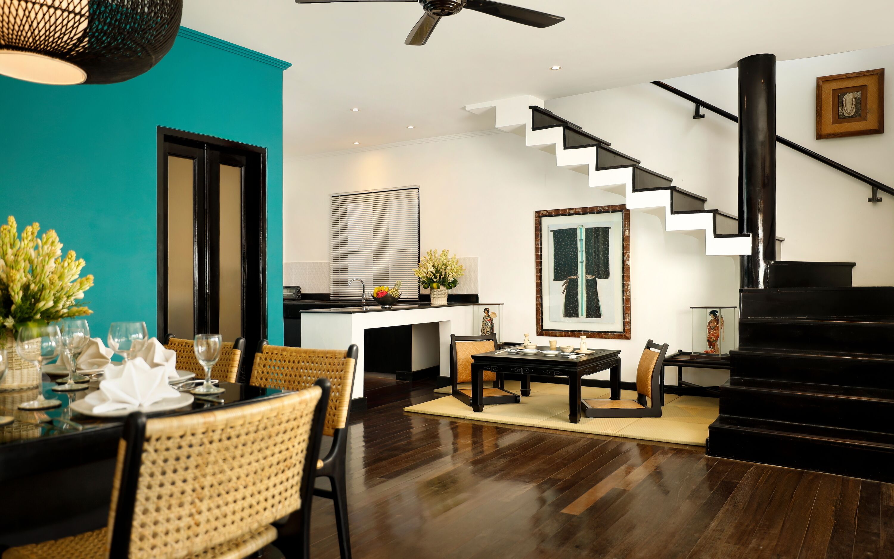 Un interno moderno con zona pranzo, cucina, scala e angolo living.