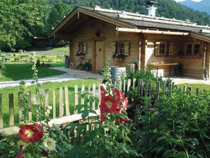 Escape to a serene cabin surrounded by lush greenery and vibrant flowers, perfect for a peaceful retreat.