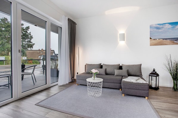 A modern living room with a sofa, a round side table, and a large window.