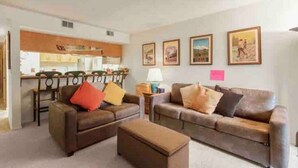 A living room with two sofas, a coffee table, and a kitchen in the background. - Amazing Views, hot tubs, pool, sauna and plenty of parking at cozy Frisco condo (Frisco)