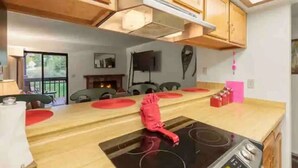 A kitchen with wooden cabinets, a black stove, and a dining table with red placemats. - Amazing Views, hot tubs, pool, sauna and plenty of parking at cozy Frisco condo (Frisco)